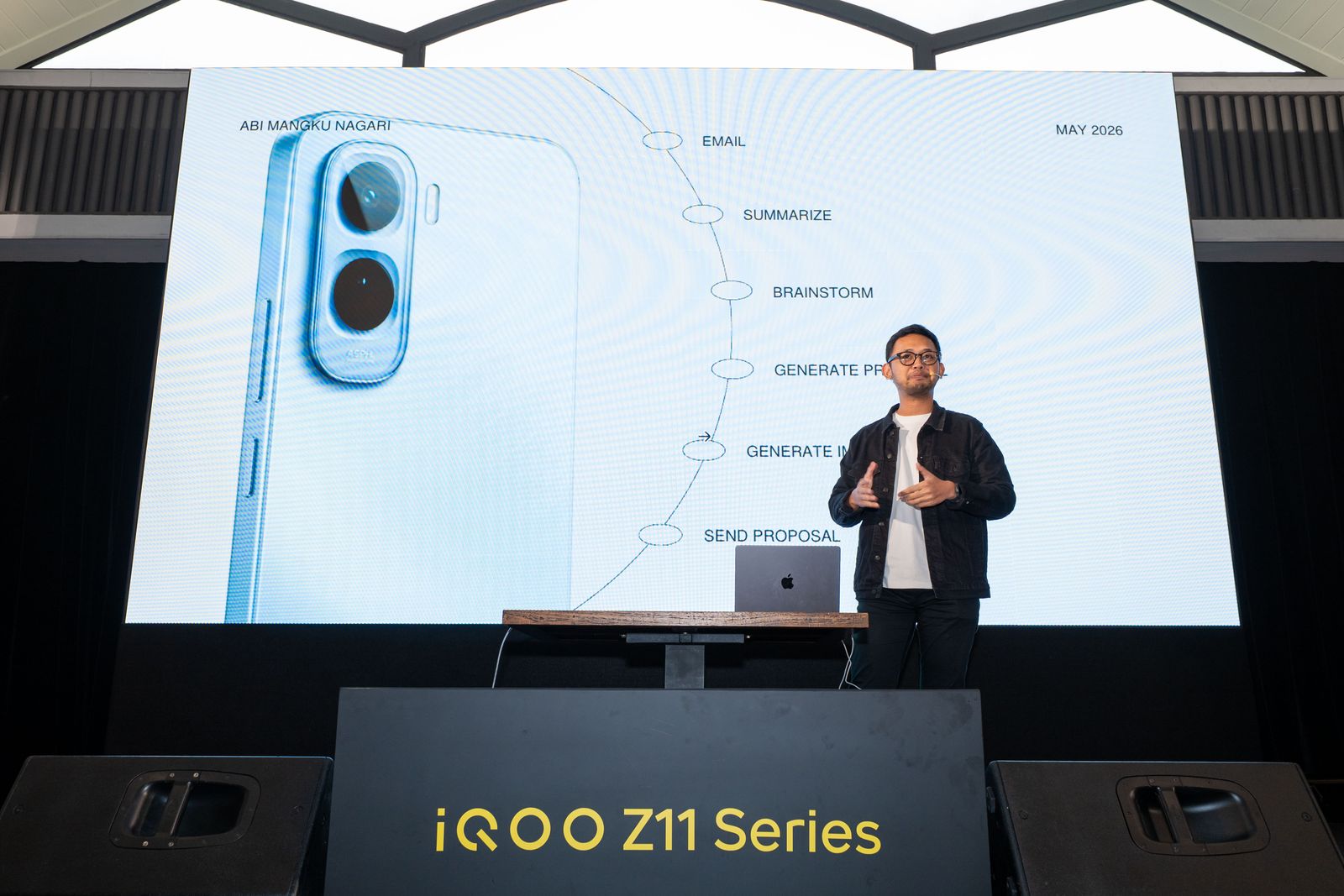 Abi Mangku on stage at the iQOO Z11 Series launch, walking an audience through a real AI workflow from email to sending a proposal